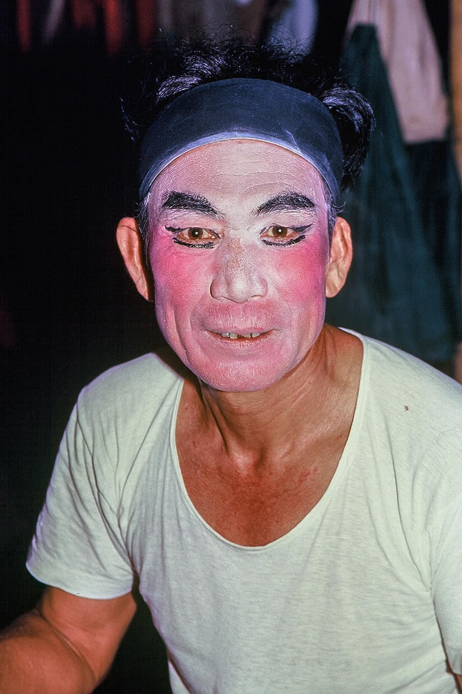 A man sits back stage waiting to perform in a Chinese opera.