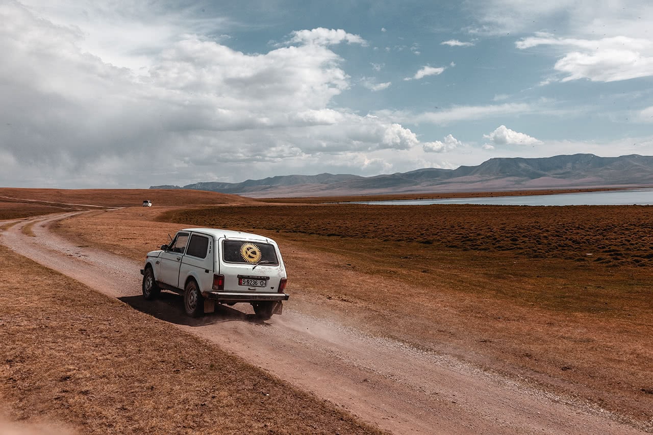 Russian 4wd car driving along Song Kul lake in Kyrgyzstan.