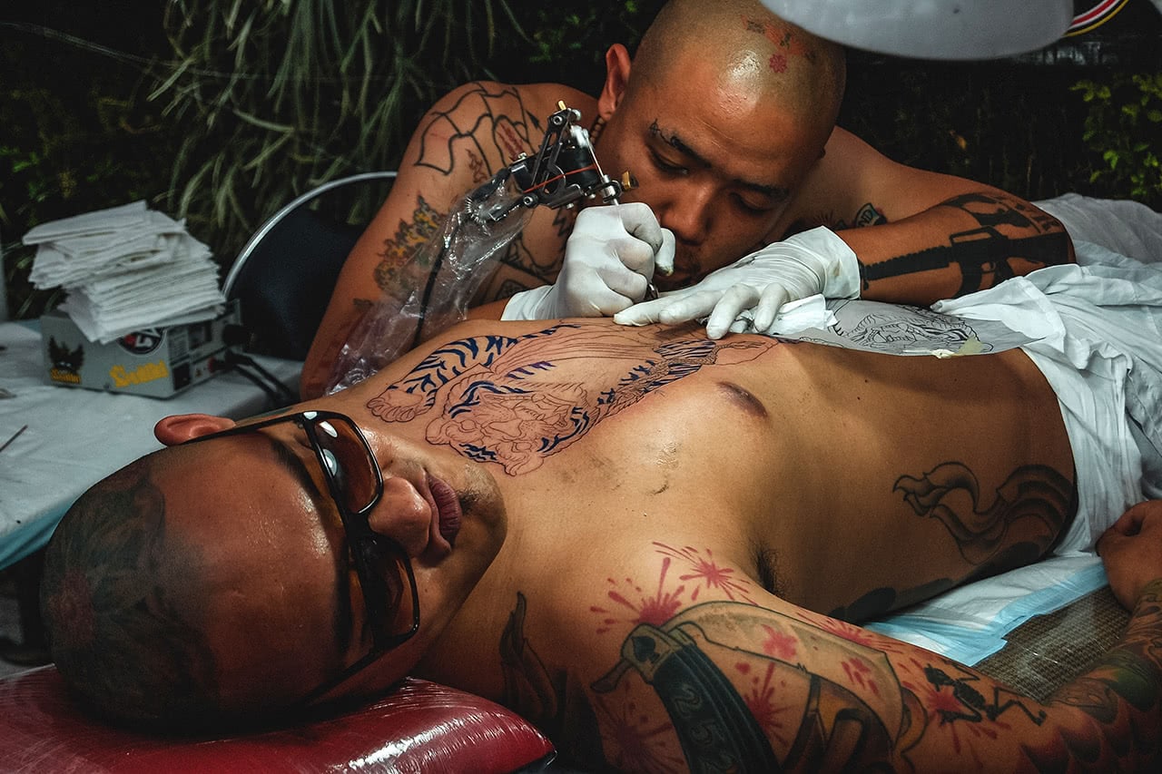 A man being tattooed in Bangkok.